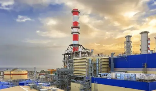 A massive power plant with a towering chimney emitting smoke.